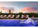Chic poolside lounge area featuring comfortable loungers with striped cushions and umbrellas for a resort-like experience at 8734 E Amelia Ave, Scottsdale, AZ 85251