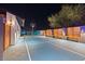Night view of the backyard basketball and tennis sport court with custom seating and lighting at 8734 E Amelia Ave, Scottsdale, AZ 85251