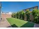 Spacious backyard featuring well-maintained artificial grass and a charming brick-lined border at 10035 E Trent Ave, Mesa, AZ 85212