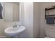Cozy half-bathroom featuring a pedestal sink, a modern faucet and a wall mirror at 10035 E Trent Ave, Mesa, AZ 85212