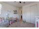 Bedroom with two windows, light colored walls, ceiling fan, and a closet with sliding doors at 10035 E Trent Ave, Mesa, AZ 85212