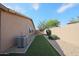 Low-maintenance backyard with gravel, artificial turf, desert trees, and a block wall at 10371 W Pontiac Dr, Peoria, AZ 85382