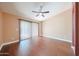 Spacious bedroom featuring wood flooring and a ceiling fan, with sliding glass doors to let in natural light at 10371 W Pontiac Dr, Peoria, AZ 85382