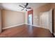 Open bedroom with wood flooring, a ceiling fan, and an adjacent ensuite bathroom, designed for comfort and privacy at 10371 W Pontiac Dr, Peoria, AZ 85382