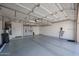 Spacious garage featuring epoxy flooring, storage cabinets, an electric vehicle charger, and overhead shelving at 10371 W Pontiac Dr, Peoria, AZ 85382