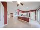 Open kitchen boasts white cabinets, stainless steel appliances, and a breakfast bar overlooking the living area at 10371 W Pontiac Dr, Peoria, AZ 85382