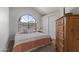 Cozy bedroom featuring a large arched window and neutral-toned decor at 10733 W Clover Way, Avondale, AZ 85392