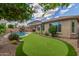Spacious backyard with a pool, putting green, mature landscaping, and comfortable outdoor seating at 10741 W Paso Trl, Peoria, AZ 85383