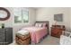 Cozy bedroom featuring a pink bed, shuttered window, and decorative accents at 10741 W Paso Trl, Peoria, AZ 85383