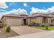Charming home featuring a well-maintained front yard and a two-car garage with brick paved driveway at 10741 W Paso Trl, Peoria, AZ 85383