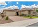 Charming single-story home boasts a well-manicured front yard with a brick driveway and neutral-toned stucco exterior at 10741 W Paso Trl, Peoria, AZ 85383