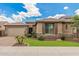 Inviting single-story home with a two car garage, manicured lawn, and neutral stucco exterior featuring stone accents at 10741 W Paso Trl, Peoria, AZ 85383