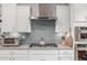 A closer view of the kitchen's stainless steel stove and range with white cabinets at 10741 W Paso Trl, Peoria, AZ 85383