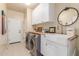 Well-organized laundry room featuring a modern washer and dryer, ample counter space, and a farmhouse sink at 10741 W Paso Trl, Peoria, AZ 85383