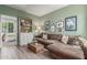Living room featuring a comfortable brown sectional, and view into an adjoining room at 10741 W Paso Trl, Peoria, AZ 85383