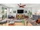 Open-concept living room featuring comfortable seating, a modern entertainment center, and hardwood floors at 10741 W Paso Trl, Peoria, AZ 85383