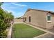 Backyard featuring plush artificial grass, desert landscaping, and privacy at 10743 W Bronco Trl, Peoria, AZ 85383