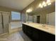 Bright bathroom features a double sink vanity, separate tub, and glass enclosed shower at 10743 W Bronco Trl, Peoria, AZ 85383