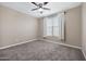 Cozy bedroom features neutral carpet, ceiling fan, and window with natural light at 10743 W Bronco Trl, Peoria, AZ 85383