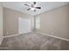 Bedroom with neutral paint, carpet, ceiling fan, and a closet with sliding doors at 10743 W Bronco Trl, Peoria, AZ 85383
