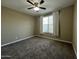 This bedroom has neutral colored walls and carpet with a ceiling fan and window at 10743 W Bronco Trl, Peoria, AZ 85383