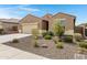 Charming single-story home featuring a desert landscaped front yard and an attached two car garage at 10743 W Bronco Trl, Peoria, AZ 85383