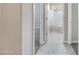 Hallway leading to a bathroom, with neutral colors and tile and carpet flooring at 10743 W Bronco Trl, Peoria, AZ 85383
