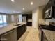 Modern kitchen featuring stainless steel appliances, dark cabinets, and a granite countertop island at 10743 W Bronco Trl, Peoria, AZ 85383