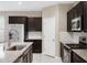 Modern kitchen featuring dark cabinets, granite countertops, stainless steel appliances and a center island at 10743 W Bronco Trl, Peoria, AZ 85383