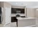 Modern kitchen featuring dark cabinets, granite countertops, stainless steel appliances and a center island at 10743 W Bronco Trl, Peoria, AZ 85383