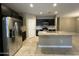 Modern kitchen featuring stainless steel appliances, dark cabinets, and a granite countertop island at 10743 W Bronco Trl, Peoria, AZ 85383