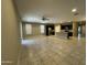 Spacious living room with tile flooring, ceiling fan, and an adjacent modern kitchen at 10743 W Bronco Trl, Peoria, AZ 85383