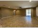 Open-concept living room with tile floors, ceiling fan, and sliding glass doors to the patio at 10743 W Bronco Trl, Peoria, AZ 85383