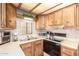 Kitchen features wooden cabinets, stainless appliances, and neutral countertops at 111 S Greenfield Rd # 119, Mesa, AZ 85206