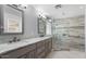 Bathroom boasts dual sinks, granite counters, and a glass-enclosed shower with decorative tile at 11342 E Laguna Azul Cir, Mesa, AZ 85209