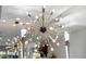 Striking modern chandelier with multiple lights, reflecting in a mirrored wall, above a dining area at 11342 E Laguna Azul Cir, Mesa, AZ 85209