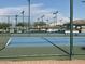 Scenic view of blue tennis courts with well-maintained netting and lighting, set in a lovely community at 11342 E Laguna Azul Cir, Mesa, AZ 85209