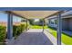 Spacious covered patio featuring brick pavers, synthetic grass, and beautifully landscaped backyard at 11656 W Luxton Ln, Avondale, AZ 85323