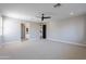 Spacious carpeted bedroom featuring an adjacent bathroom and doorway to the kitchen at 11656 W Luxton Ln, Avondale, AZ 85323