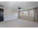 Spacious bedroom features plush carpet, modern ceiling fan, and natural light from many windows at 11656 W Luxton Ln, Avondale, AZ 85323