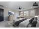 This staged primary bedroom features carpet, a ceiling fan, and natural light from many windows at 11656 W Luxton Ln, Avondale, AZ 85323
