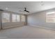 Spacious carpeted bedroom with many windows and a modern ceiling fan at 11656 W Luxton Ln, Avondale, AZ 85323