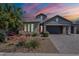 Beautiful single-story home featuring a three-car garage and lush landscaping with brick accents on the facade at 11656 W Luxton Ln, Avondale, AZ 85323