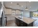 Spacious kitchen featuring stainless steel appliances, a large island, and an open floorplan to the living area at 11656 W Luxton Ln, Avondale, AZ 85323