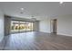 Spacious living room with wood-look tile floors and sliding glass doors to the backyard at 11656 W Luxton Ln, Avondale, AZ 85323