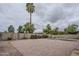 Spacious gravel backyard with block wall, palm trees, and a pool at 12228 S Pewaukee St, Phoenix, AZ 85044