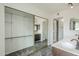 Bathroom featuring dual sinks, dark cabinets, walk-in closet and a framed mirror at 12228 S Pewaukee St, Phoenix, AZ 85044