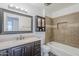 Updated bathroom featuring a vanity, mirror, tiled shower-tub, and cabinet at 12228 S Pewaukee St, Phoenix, AZ 85044