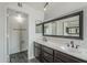 Bathroom features dual sinks, dark cabinets, and a large, framed mirror at 12228 S Pewaukee St, Phoenix, AZ 85044