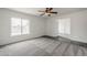 Spacious room featuring a ceiling fan, grey carpet, and a large window with great light at 12228 S Pewaukee St, Phoenix, AZ 85044
